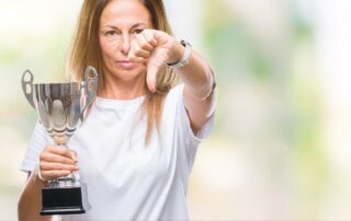 Woman putting her thumb down with a trophy