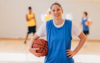 Young woman in blue jersey with basketball